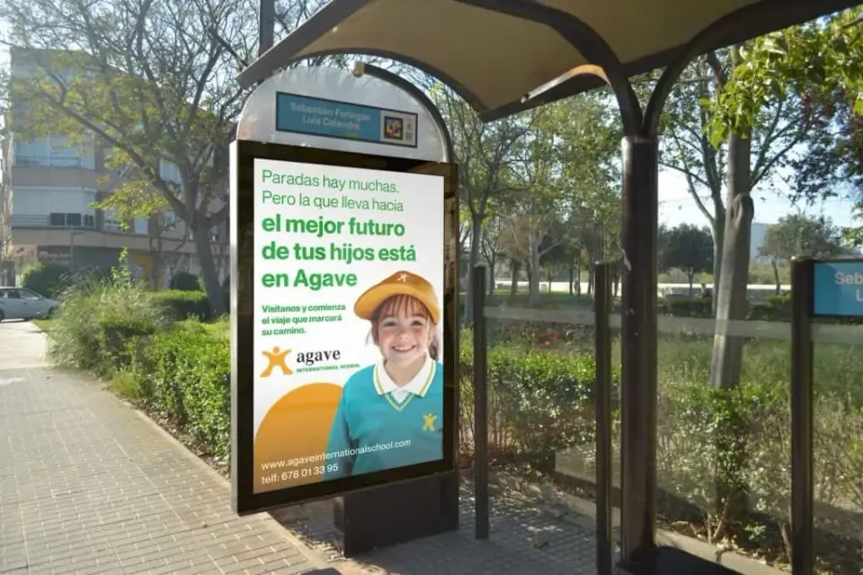 Parada de autobús con anuncio de Agave International School.