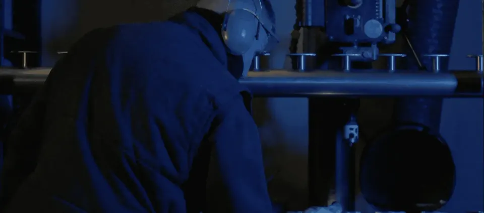Persona trabajando en un entorno industrial con equipo técnico.